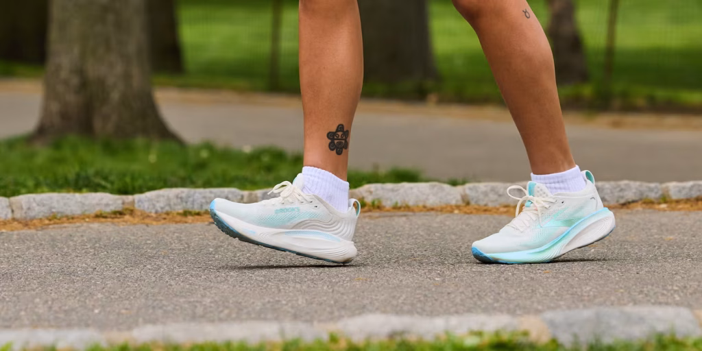 Person walking on a path wearing socks and running shoes